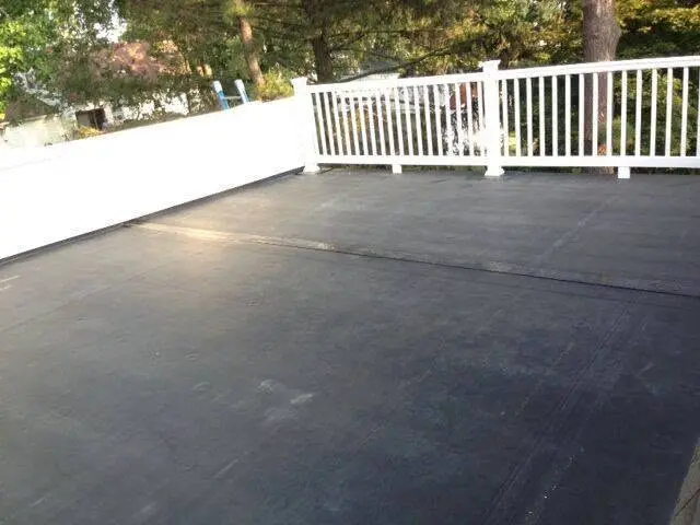 Completed residential flat roof installation with a white perimeter railing